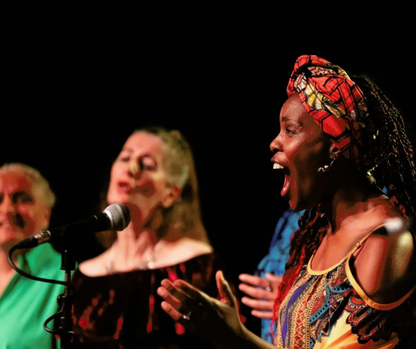 Three singers perform onstage.