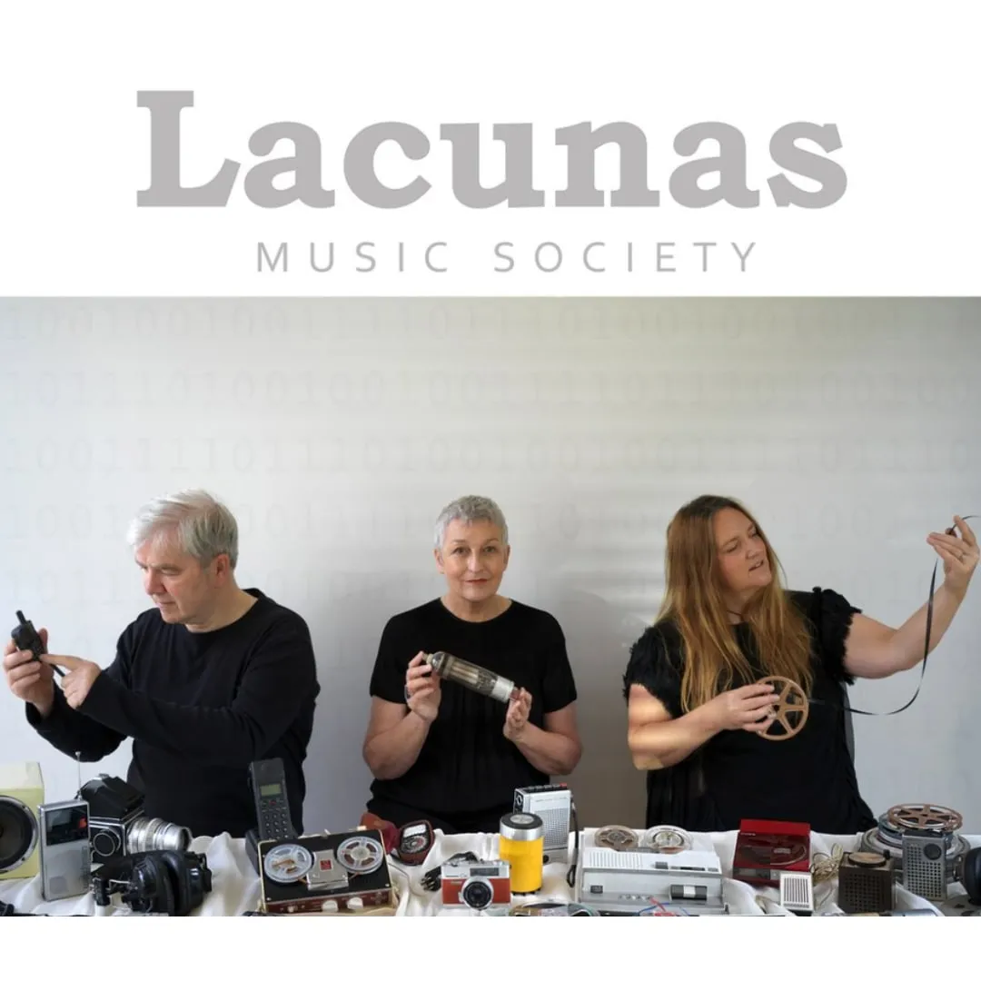 (From left) Malcolm Lindsay, Blythe Duff and Yvonne Lyon stand facing the camera at a long table covered in a white tablecloth. They are busy holding, exploring or playing with various pieces of audio equipment spread over the table. Photo credit: Melanie Sims